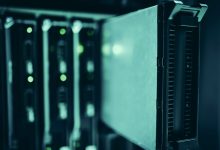 Close de racks de servidores em um data center moderno, com iluminação azul e indicadores luminosos.