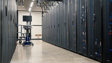 Armários metálicos com servidores, equipamentos de rede e cabos em um data center moderno.